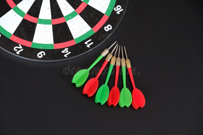 Dart sports branch, dartboard and colorful dart arrows on black ground stock photos Dart sports branch, dartboard and colorful dart arrows on black ground stock photos