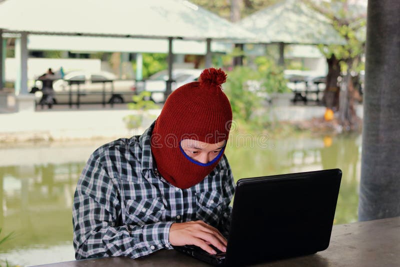 Das anonyme Hackerzerhacken stehlen Daten mit Laptop Sozialverbrechenkonzept stockfotografie