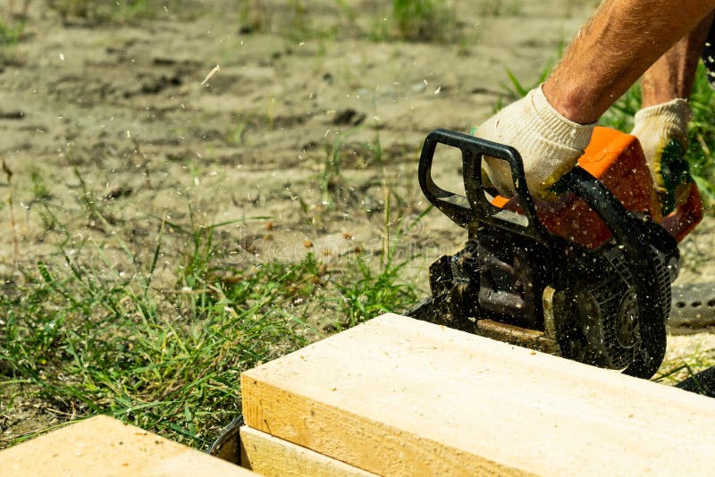 Das Arbeiten mit einer Kettensäge schnitt die Dachsparren, um zu sortieren stockfotografie Das Arbeiten mit einer Kettensäge schnitt die Dachsparren, um zu sortieren stockfotografie