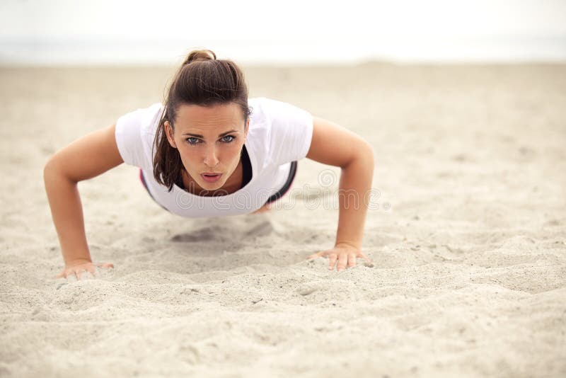 Das athletische Frauen-Handeln drückt auf den Strand hoch lizenzfreie stockfotos Das athletische Frauen-Handeln drückt auf den Strand hoch lizenzfreie stockfotos