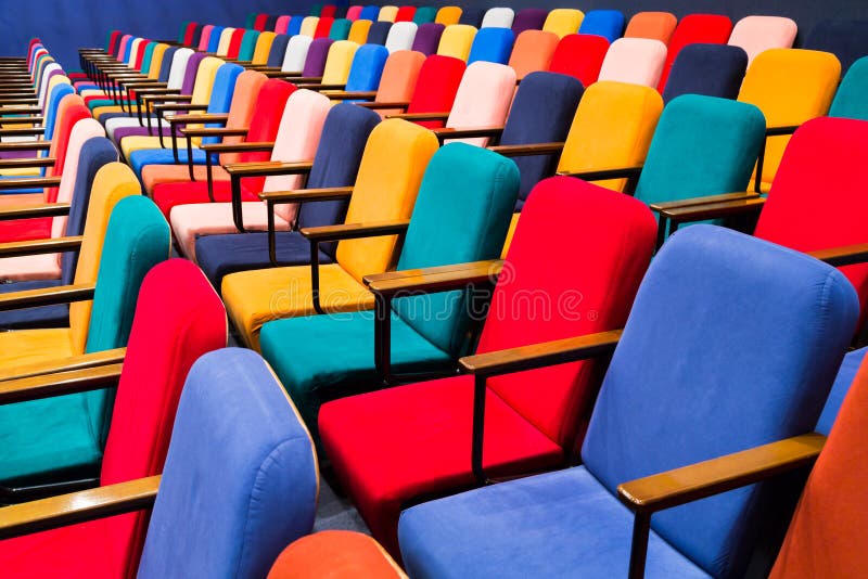 The auditorium in the theater. Multicolored spectator chairs. The auditorium in the theater. Multicolored spectator chairs.