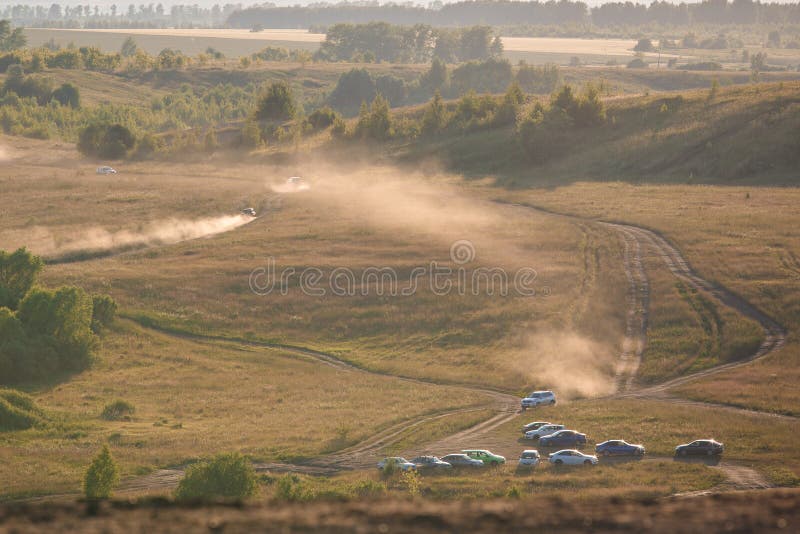 Das Auto fährt auf ein leeres Sandfeld und eine gelbe Spalte von Staubaufstiegen lizenzfreies stockfoto Das Auto fährt auf ein leeres Sandfeld und eine gelbe Spalte von Staubaufstiegen lizenzfreies stockfoto