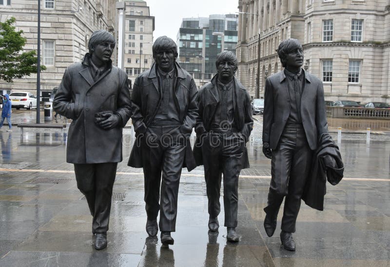 Bronze statue of the Beatles at the Waterfrontin Liverpool, UK. It was created by the sculporr Andrew Edwards. Th wether is typical english, it rains. Bronze statue of the Beatles at the Waterfrontin Liverpool, UK. It was created by the sculporr Andrew Edwards. Th wether is typical english, it rains