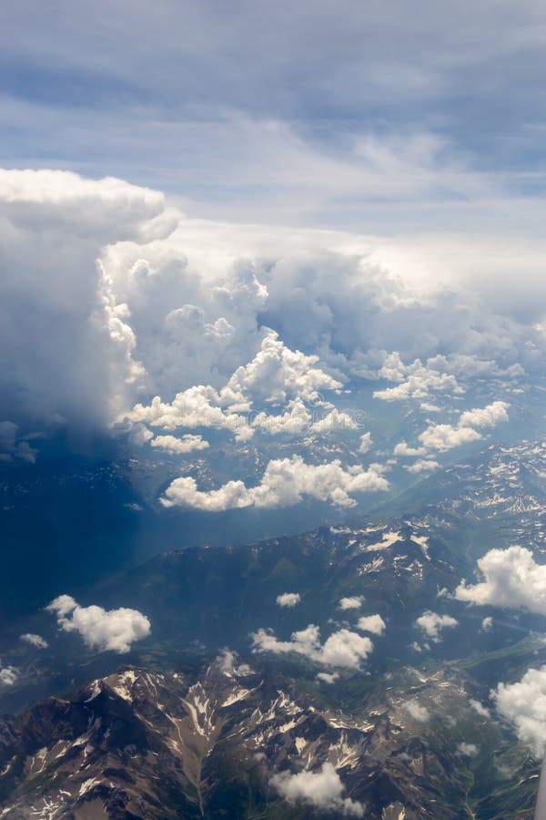 Das bird' s-Augenansicht über den Himmel mit den enormen flaumigen drastischen Wolken über den Alpen stockfoto Das bird' s-Augenansicht über den Himmel mit den enormen flaumigen drastischen Wolken über den Alpen stockfoto