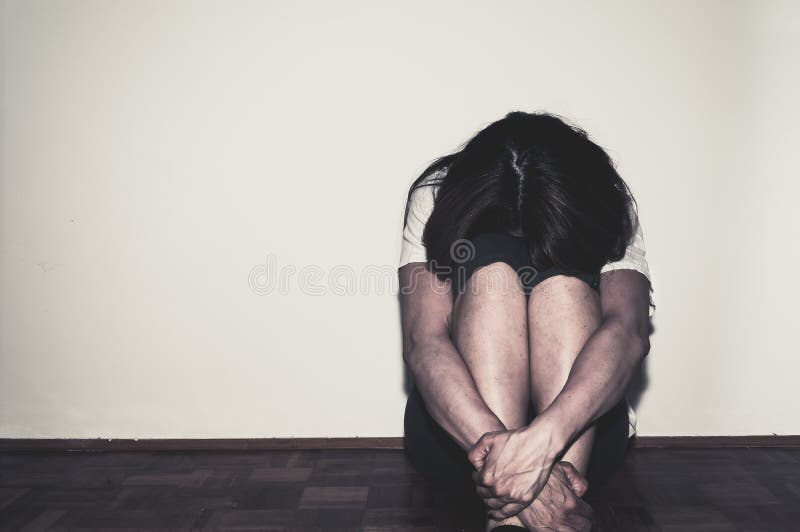 Das deprimierte und einsame Mädchen, das als Junge allein sitzen in ihrem Raum auf dem elenden Bodengefühl und Angst missbraucht stockfoto