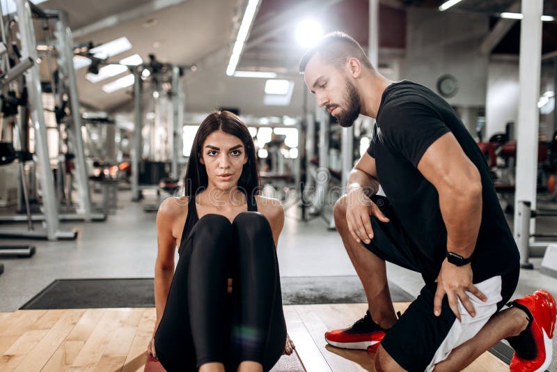 Das dünne Mädchen, das in der schwarzer Sportspitze und -strumpfhosen gekleidet wird, tut Übungen für die abdominals auf der Eign lizenzfreies stockbild