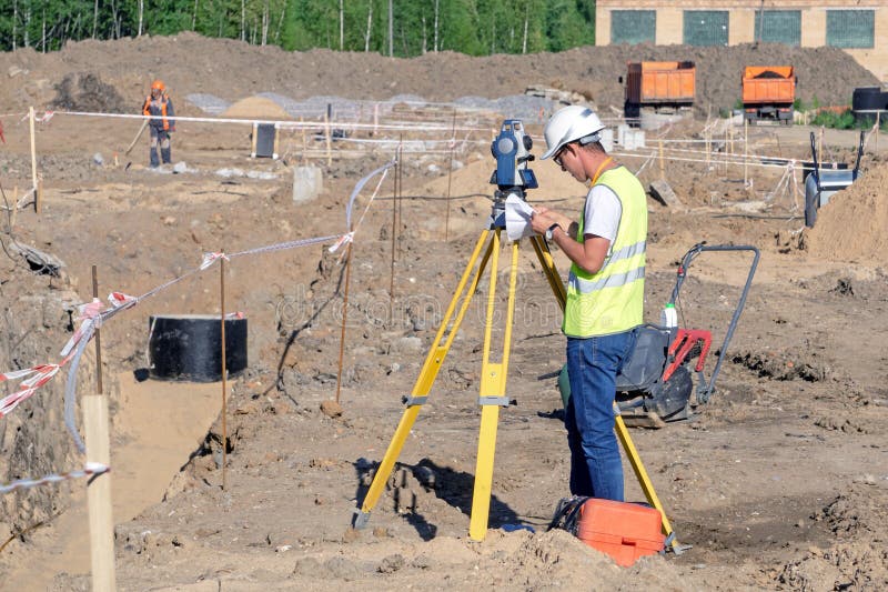 Das Feldmesser führt topographische Übersicht des Bereichs für den cad durch lizenzfreie stockfotografie Das Feldmesser führt topographische Übersicht des Bereichs für den cad durch lizenzfreie stockfotografie