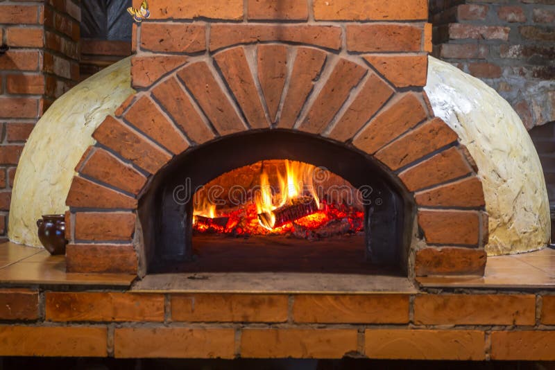 Das Feuer brennt in einem hölzernen Pizzaofen lizenzfreie stockfotos Das Feuer brennt in einem hölzernen Pizzaofen lizenzfreie stockfotos