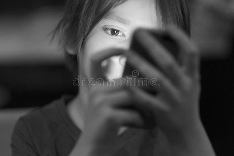 Das Gesicht des Kindes, hervorgehoben durch das Telefon lizenzfreie stockbilder Das Gesicht des Kindes, hervorgehoben durch das Telefon lizenzfreie stockbilder
