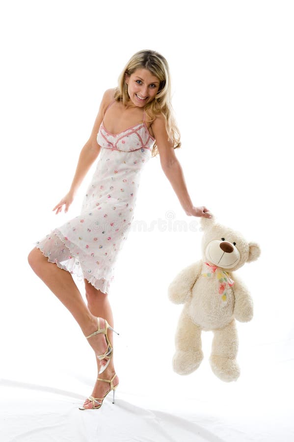 Das junge, bezaubernde Mädchen spielt mit einem Bären stockbilder