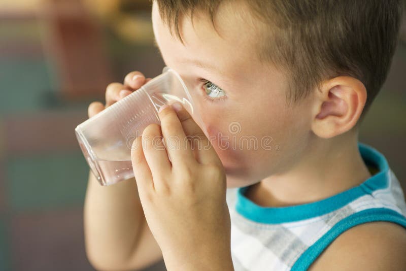 Das Kind hält ein Plastiktasse wasser in seinen Händen Kind trinkt Wasser Netter kleiner Junge, der Süßwasser von der Plastikscha lizenzfreie stockbilder Das Kind hält ein Plastiktasse wasser in seinen Händen Kind trinkt Wasser Netter kleiner Junge, der Süßwasser von der Plastikscha lizenzfreie stockbilder