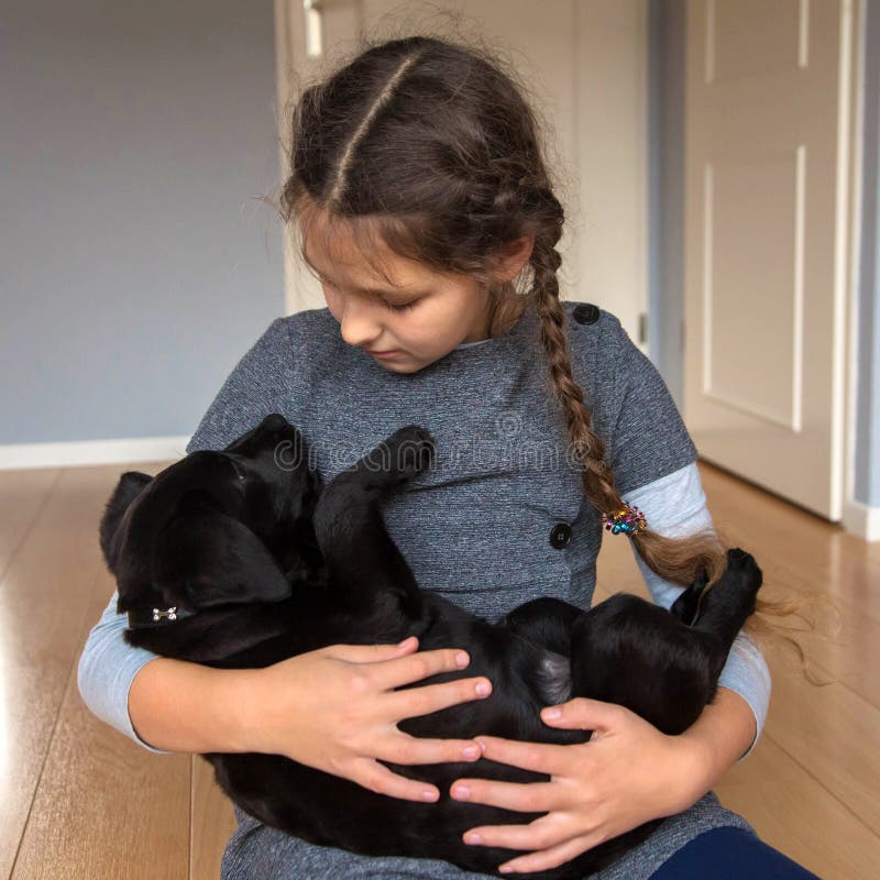Das Kind hält einen Labrador-Welpen lizenzfreie stockfotos Das Kind hält einen Labrador-Welpen lizenzfreie stockfotos