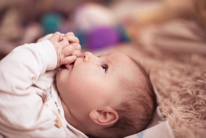 Das Kind liegt auf dem Bett stockfotografie Das Kind liegt auf dem Bett stockfotografie