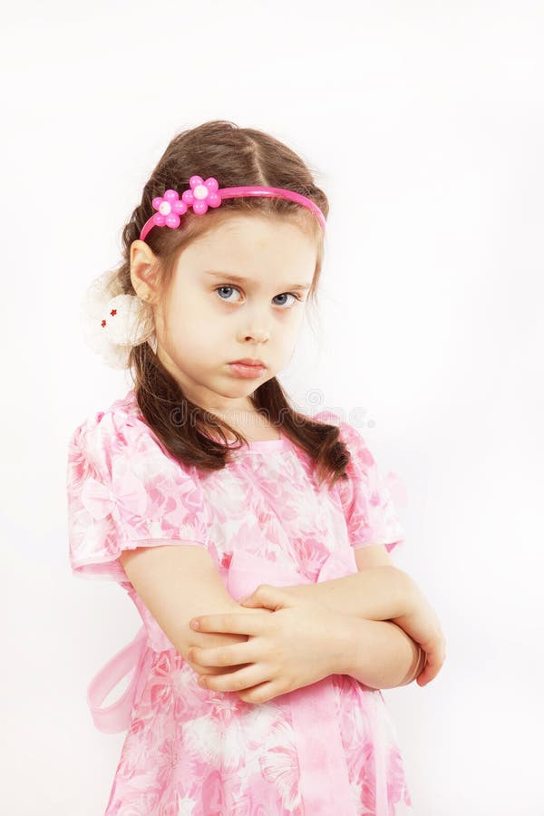 Das kleine hübsche Mädchen, das schönes rosa Kleid trägt, ist verärgert stockbild Das kleine hübsche Mädchen, das schönes rosa Kleid trägt, ist verärgert stockbild