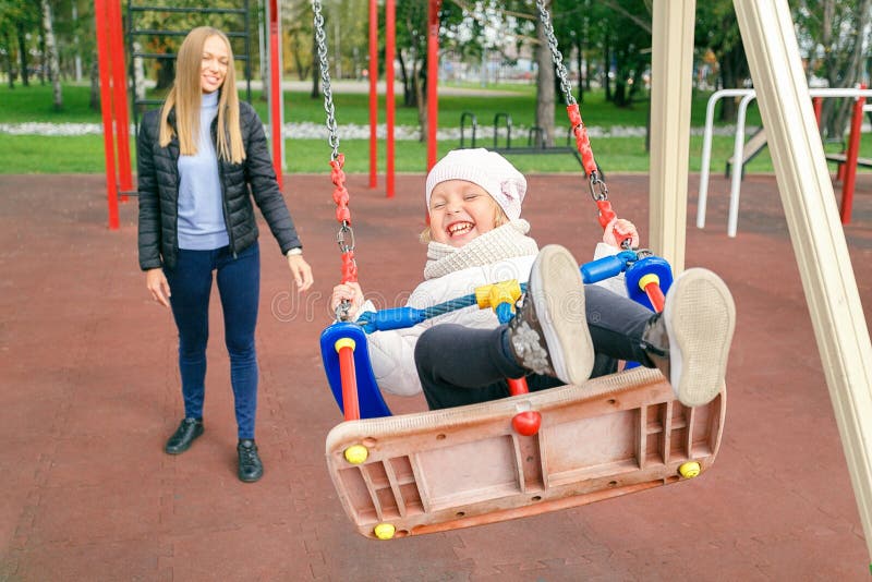 Das kleine Mädchen, das auf der Schaukel spielt lizenzfreie stockfotografie Das kleine Mädchen, das auf der Schaukel spielt lizenzfreie stockfotografie