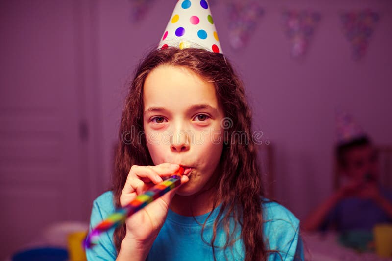 Das kleine Mädchen, das bei einer Geburtstagsfeier beruht stockbild