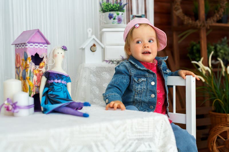 Das kleine Mädchen mit den Puppenhasen geht und lächelt lizenzfreie stockfotografie Das kleine Mädchen mit den Puppenhasen geht und lächelt lizenzfreie stockfotografie