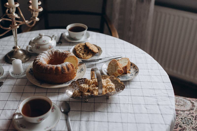 Das köstliche Dessert liegt elegant neben einer dampfenden Tasse Tee in alten Porzellanbechern lizenzfreies stockbild
