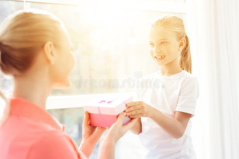 Das Mädchen bereitete eine Überraschung für ihre Mutter vor Kleines Mädchen bereitete ein Geschenk für Mutter vor stockfoto