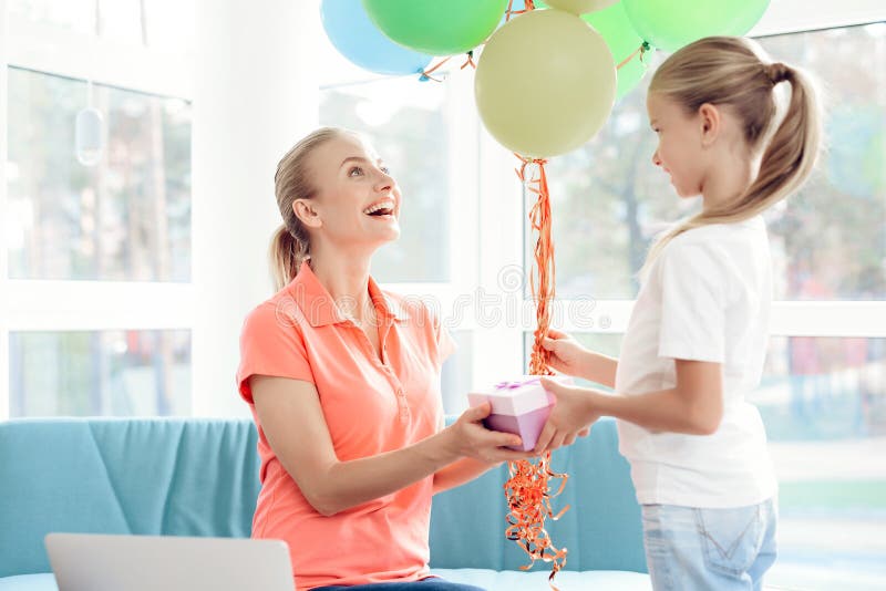 Das Mädchen bereitete eine Überraschung für ihre Mutter vor Vorbereitetes Geschenk des kleinen Mädchens für Mutter Sie hält Ballo lizenzfreies stockbild