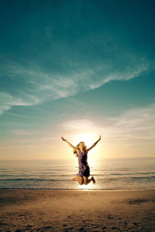Das Mädchen, das auf schönen Strand springt und tanzt.