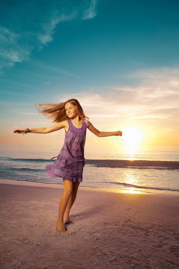 Das Mädchen, das auf schönen Strand springt und tanzt.