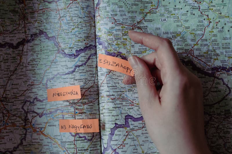 The girl gluing orange mark-ups identifying various highways in Hungary and nearby to plan the route. The girl gluing orange mark-ups identifying various highways in Hungary and nearby to plan the route.