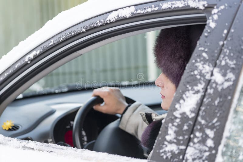 Das Mädchen sitzt am Steuer von einem Auto Im offenen Fenster von stockbild