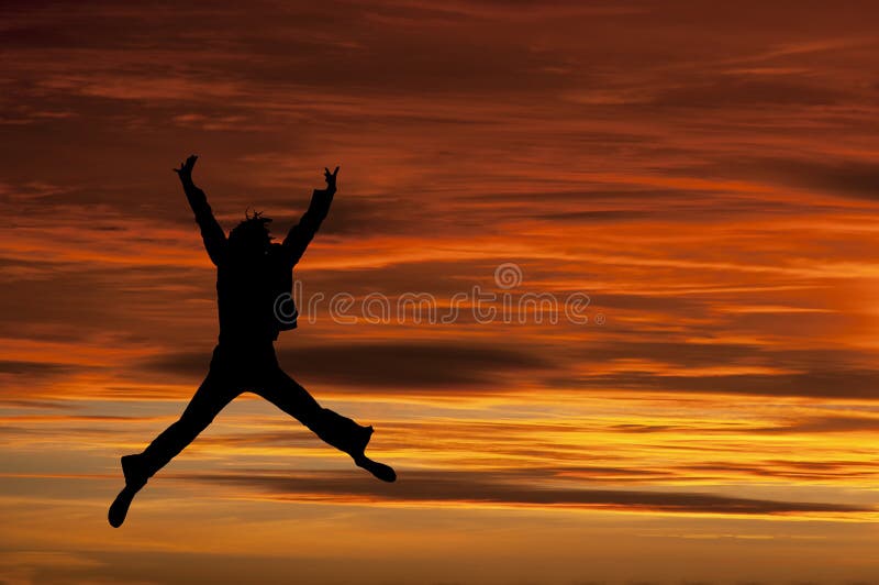 Das Mädchen springend mit Freude am Sonnenuntergang