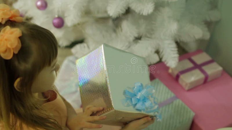 Das Mädchen öffnet Weihnachtsgeschenke am Weihnachtsbaum
