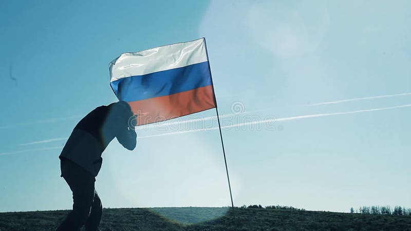 Das Schattenbild eines Mannes, der Fotos der Flagge macht