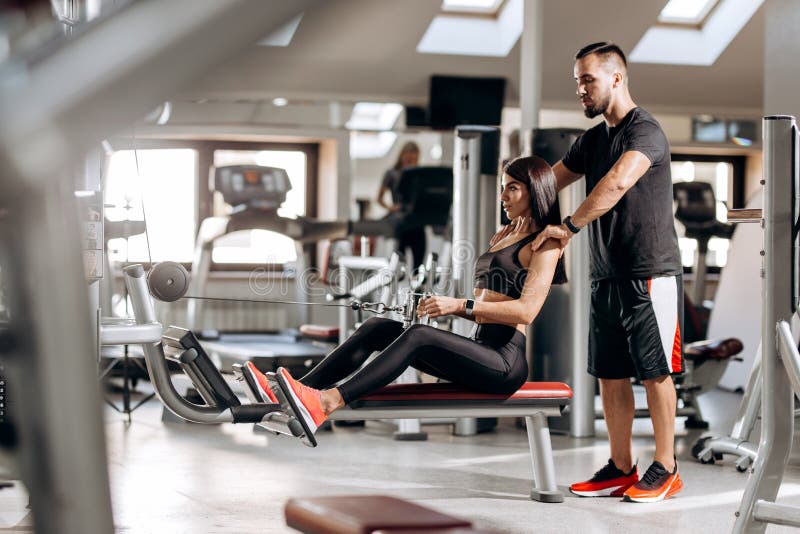 Das schöne dünne Mädchen, das in der schwarzen Sportkleidung gekleidet wird, tut Übungen für die abdominals auf einer speziellen lizenzfreie stockfotografie