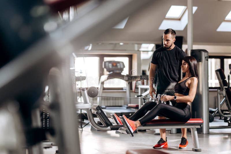 Das schöne dünne Mädchen, das in der schwarzen Sportkleidung gekleidet wird, tut Übungen für die abdominals auf einer speziellen stockbild