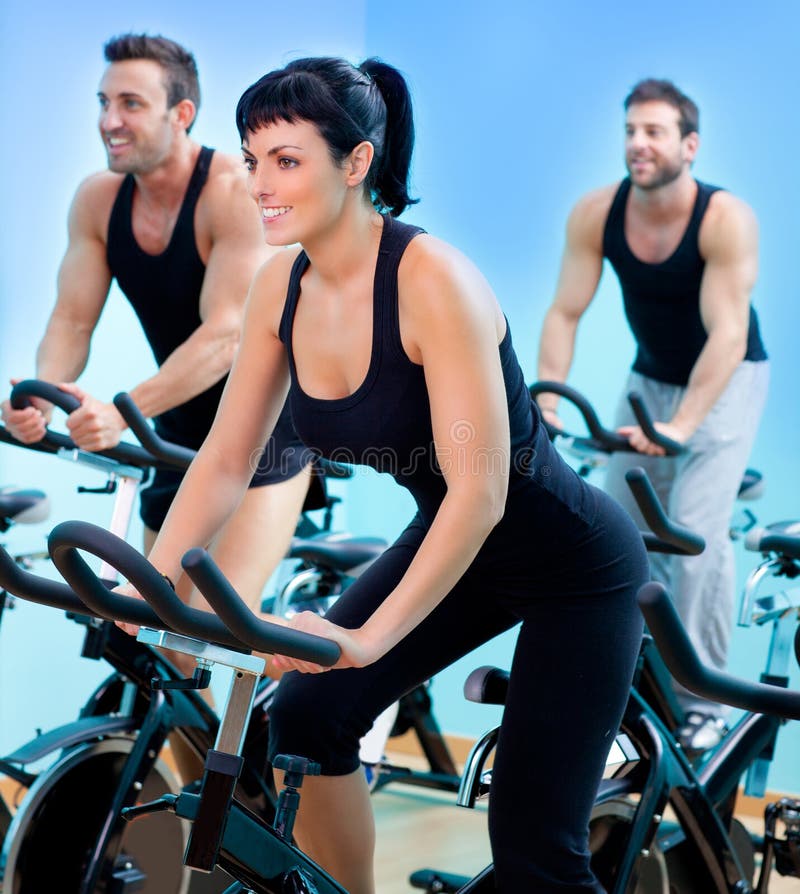 Stationary spinning bicycles fitness girl in a gym sport club. Stationary spinning bicycles fitness girl in a gym sport club