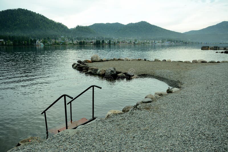 Das Ufer eines großen, schutthaltigen Sees und eine Treppe mit Geländer, die ins Wasser führen. Teletskoye See altai siberia Russland