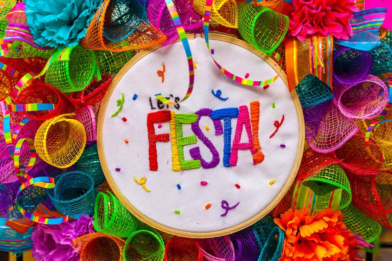 The word `fiesta` stitched in colorful letters on multicolored mash decorated with glitter and paper flowers Decoration for San Antonio Fiesta Festival. The word `fiesta` stitched in colorful letters on multicolored mash decorated with glitter and paper flowers Decoration for San Antonio Fiesta Festival