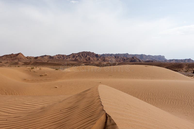 Dasht-e Kavir desert sand dunes with mountains on.