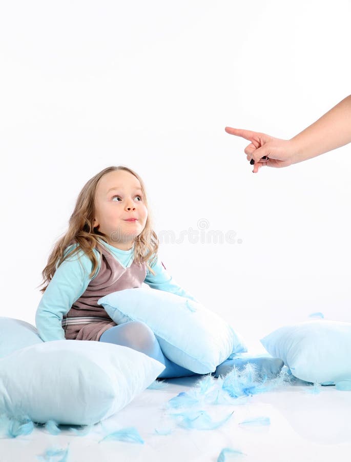 Five years old girl having fun with blue pillows and feathers on white background. Studio hi-res shot. Five years old girl having fun with blue pillows and feathers on white background. Studio hi-res shot.