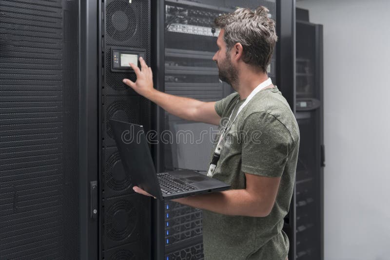 Data Center Engineer Using Laptop Computer Server Room Specialist Facility with Male System Administrator Working with royalty free stock images