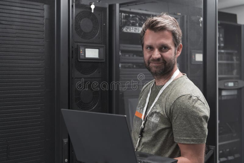 Data Center Engineer Using Laptop Computer Server Room Specialist Facility with Male System Administrator Working with stock photography
