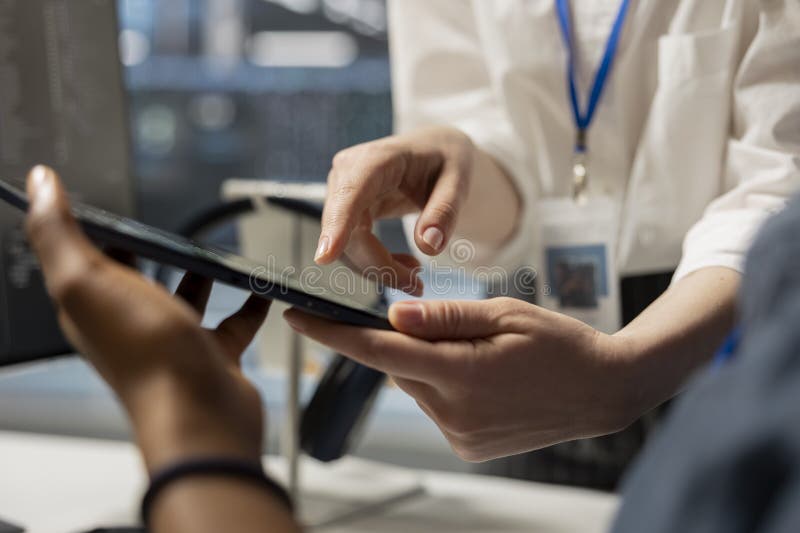 Data center engineering team analyzing software logs metrics on tablet, close up stock photos
