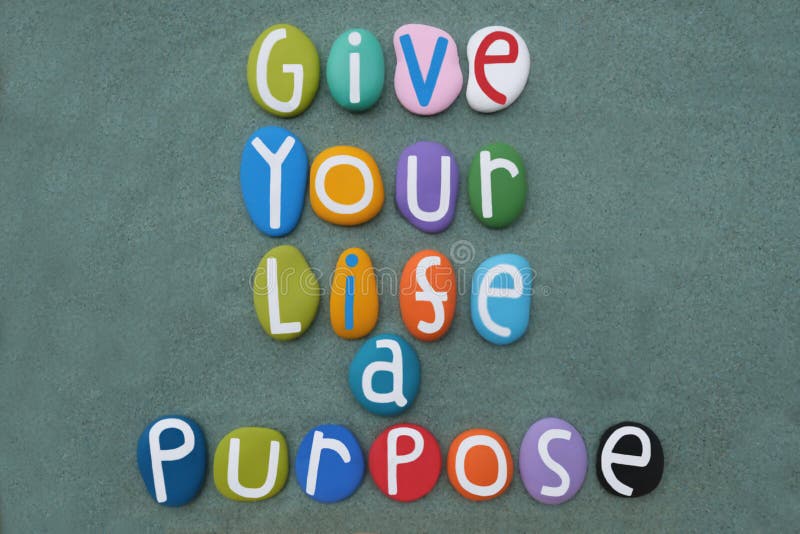 Date alla vostra vita una frase motivata composta da lettere di pietra multicolore sulla sabbia fotografie stock