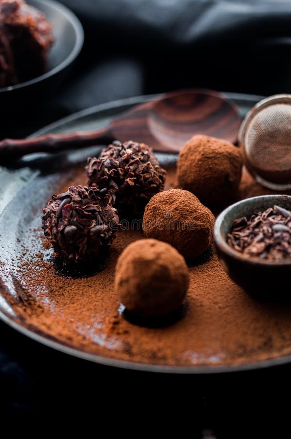 Date Energy Ball with Cocoa on a Black Dish and Cocoa Nibs Stock Image