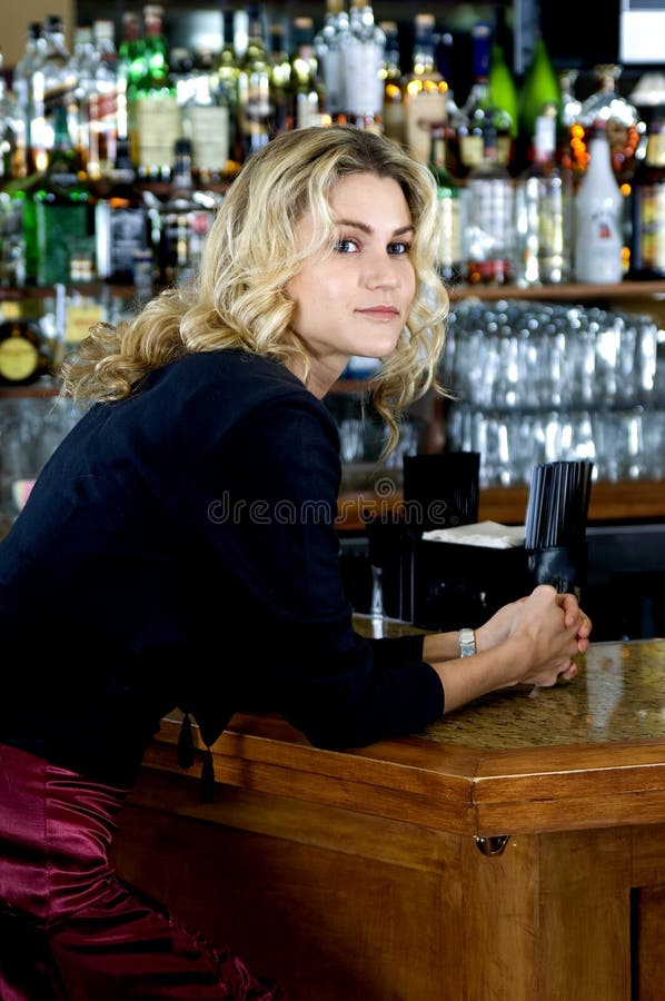 Beautiful blond woman in her late twenties sits at the bar, looking around, waiting for her date to show up. Beautiful blond woman in her late twenties sits at the bar, looking around, waiting for her date to show up