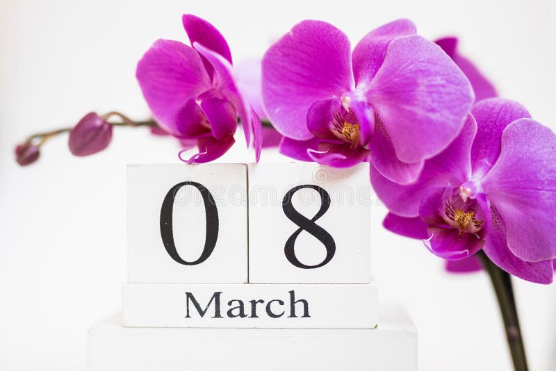 Date white block calendar for International Women`s Day, March 8, decorated with orchid flower