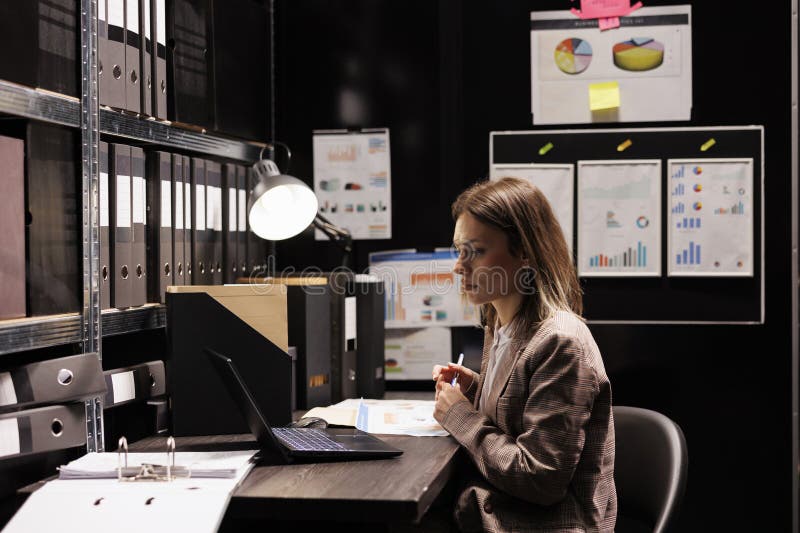 Caucasian manager analyzing files with bureaucracy report, working overtime in corporate depository. Businesswoman checking accountancy research, trying organizing documents in arhive room. Caucasian manager analyzing files with bureaucracy report, working overtime in corporate depository. Businesswoman checking accountancy research, trying organizing documents in arhive room