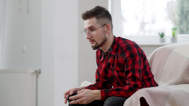 Datenzugriffsseiten-Ansicht des erschöpften männlichen Spieler, der den Gamecontroller zu Hause sitzt auf Stuhl verwendet. Porträt