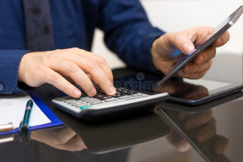 Dati di Analyzing Business dell'uomo d'affari sullo Smart Phone e sul calcula fotografia stock Dati di Analyzing Business dell'uomo d'affari sullo Smart Phone e sul calcula fotografia stock