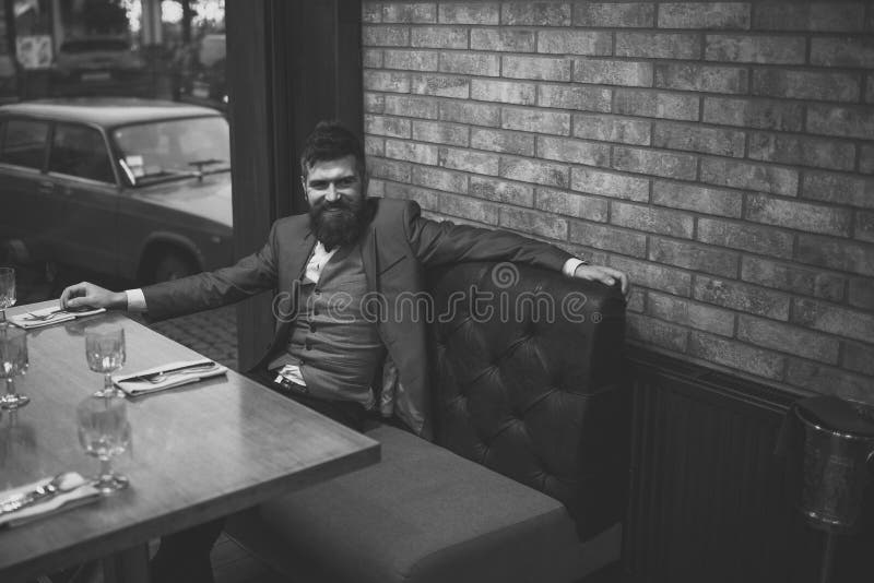 Dati la riunione che attende nel resto barbuto dell'uomo del pub in ristorante alla tavola Riunione della data dei pantaloni a vi immagine stock libera da diritti Dati la riunione che attende nel resto barbuto dell'uomo del pub in ristorante alla tavola Riunione della data dei pantaloni a vi immagine stock libera da diritti