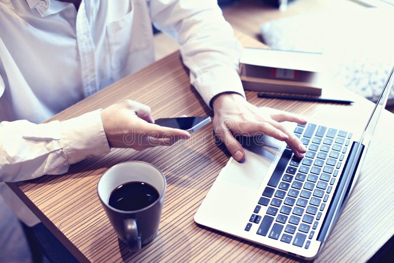 Dator för bärbar dator för bruk för redovisningsaffärsman och mobiltelefon i kafé, handstilaffärsplan som dricker kaffekaffe arkivbilder Dator för bärbar dator för bruk för redovisningsaffärsman och mobiltelefon i kafé, handstilaffärsplan som dricker kaffekaffe arkivbilder